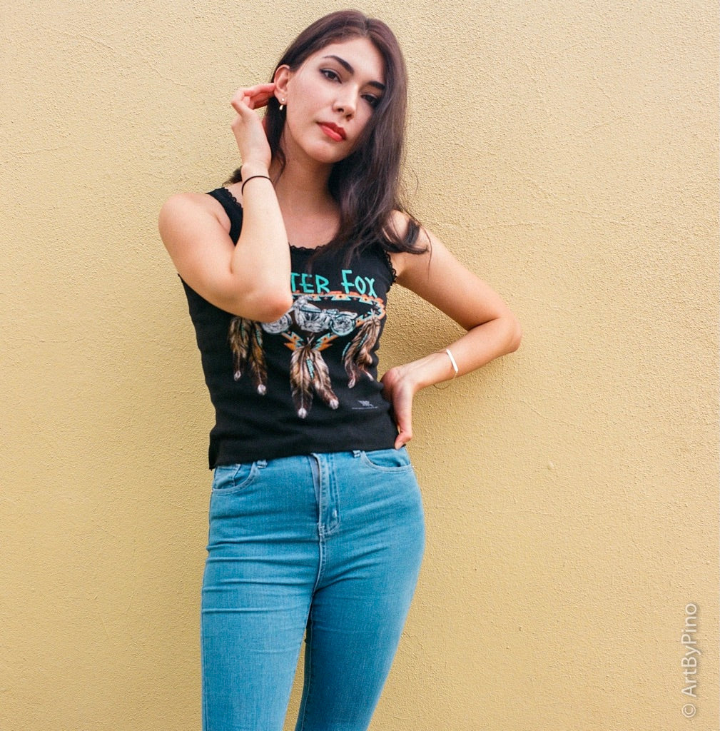 Young woman in a Silver Fox graphic tank top posing against a yellow textured wall shot on Lomography Color Negative ISO 400 120 film, developed in C-41
