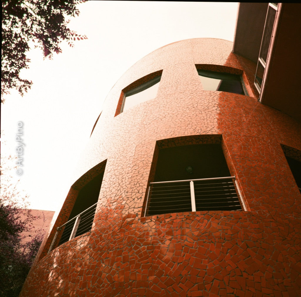 Edificio curvo con mosaico naranja de ángulo bajo — Hasselblad 500CM + LomoChrome Purple 400 + 120