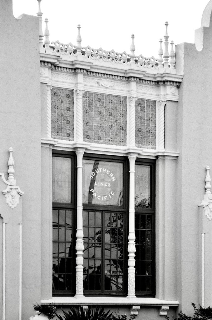 Ventana ornamentada con columnas retorcidas, remates y el letrero de Southern Pacific Lines, Estación de Southern Pacific (1927), Edinburg, Texas — Rollei Blackbird 64 35mm, Canon A2E