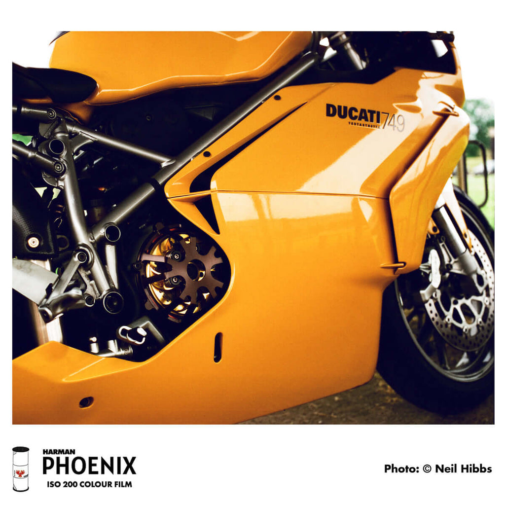 Vibrant orange ducati 749 sport motorcycle with sleek metallic bodywork and exposed mechanical components.