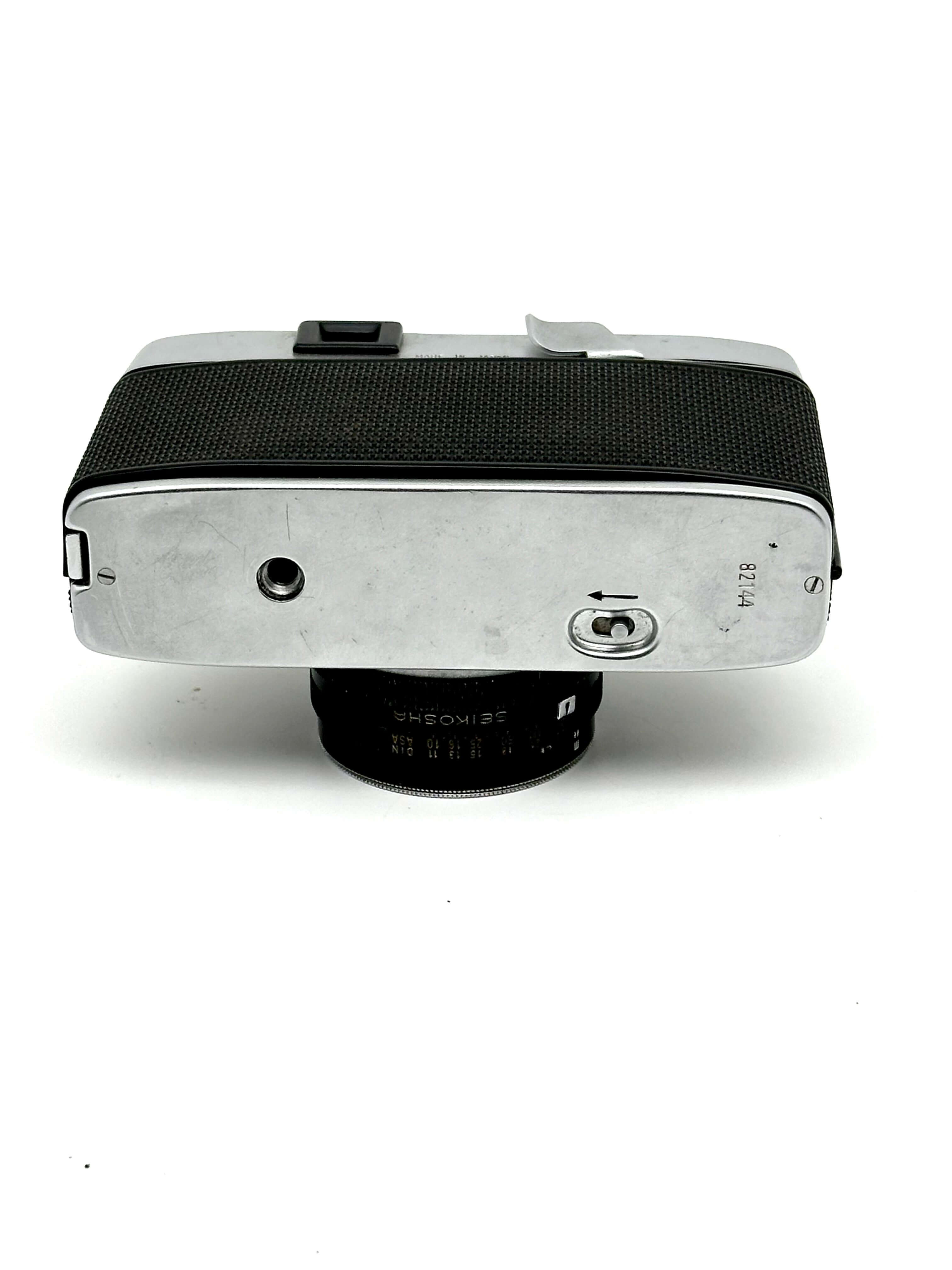 Silver-bodied rangefinder camera with black textured grip and a 35mm lens.