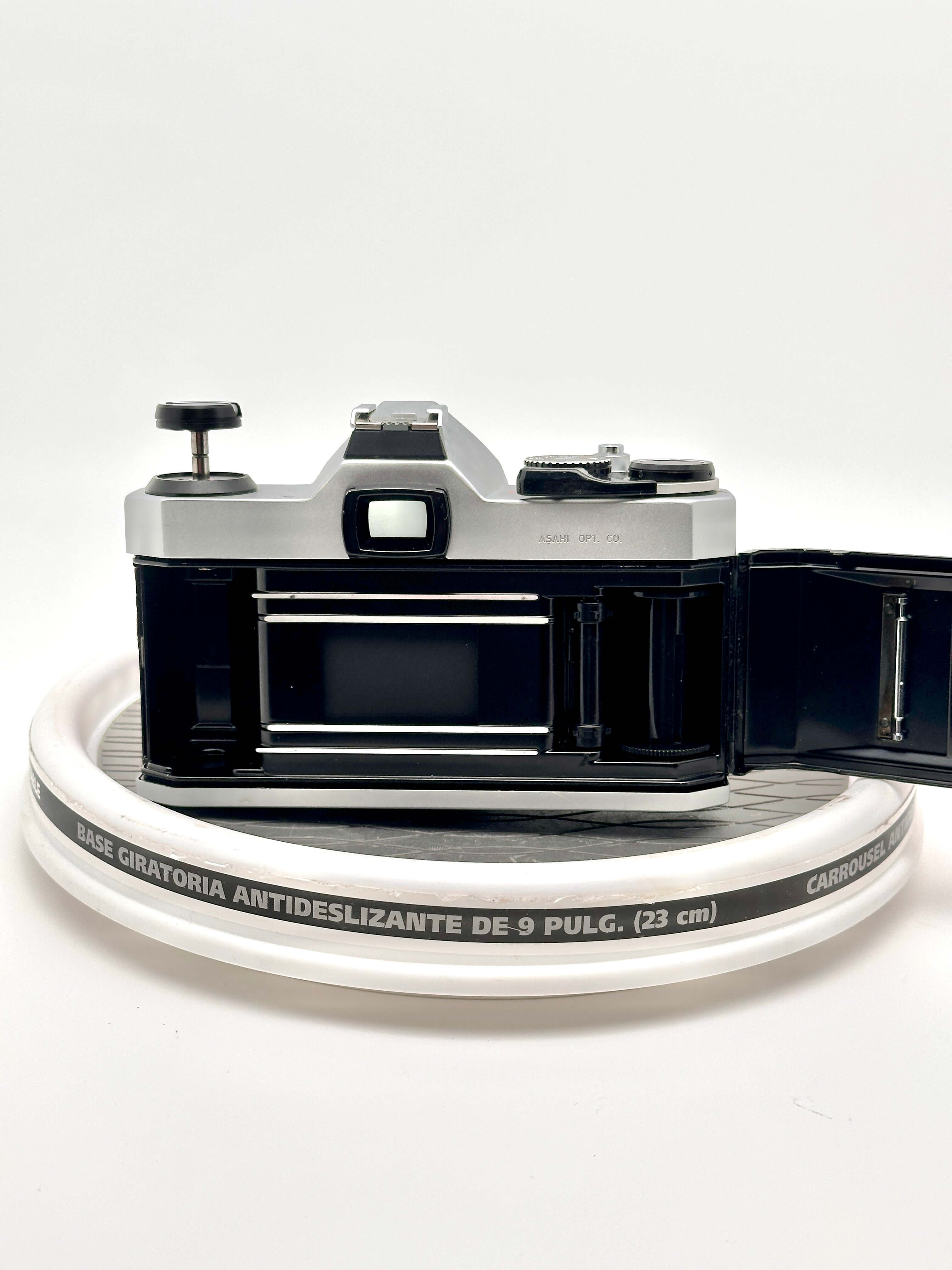 Silver-bodied canon ae-1 film camera with black accents and a visible shutter release button.
