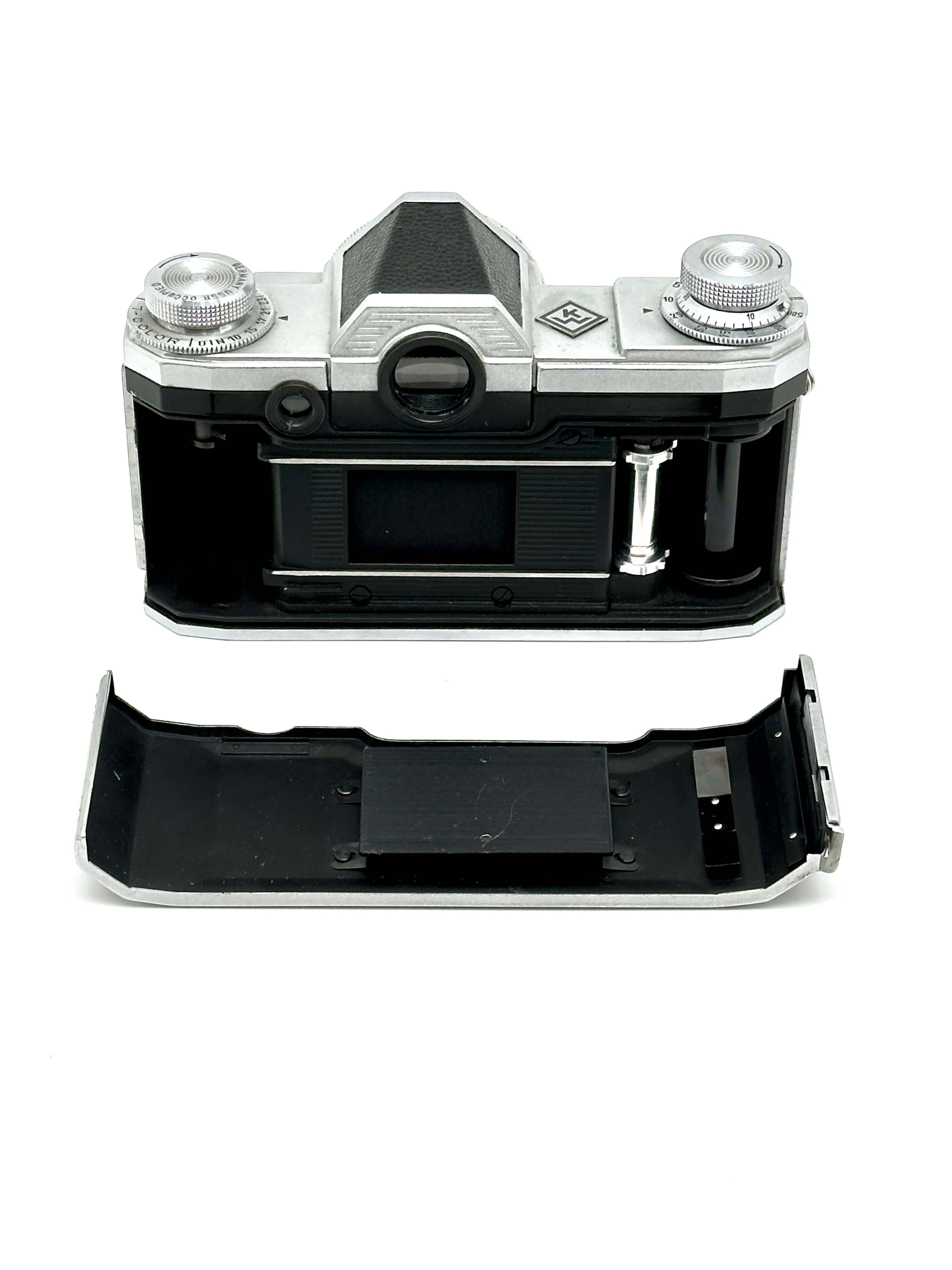 Silver and black kodak retina 35 film camera body with exposed internal components.