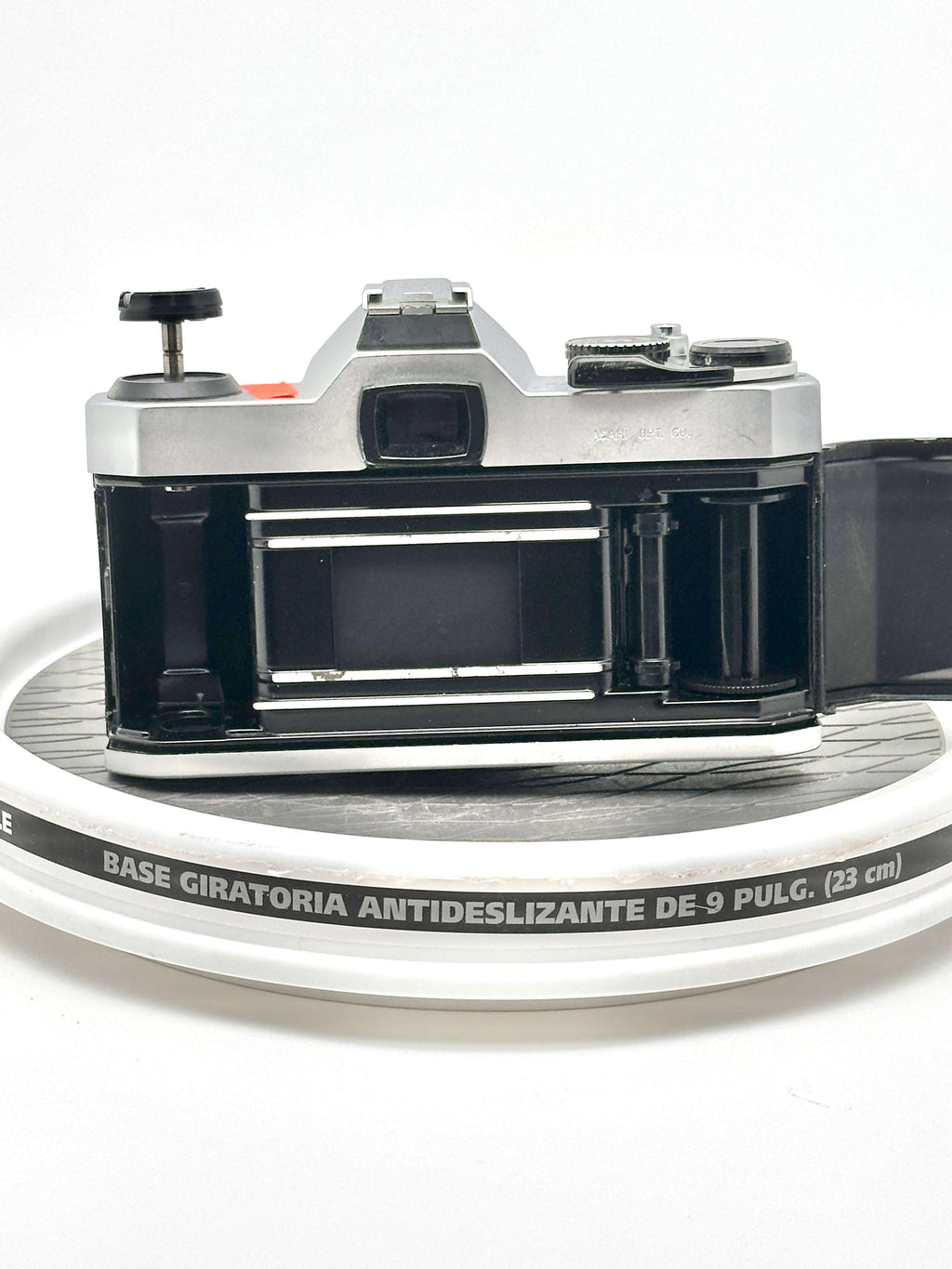 Silver and black vintage film camera with a metallic body, exposed shutter mechanism, and visible lens mount.