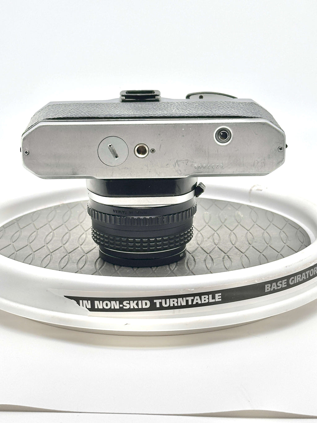 Silver-bodied, textured top camera with a black lens mounted on it.