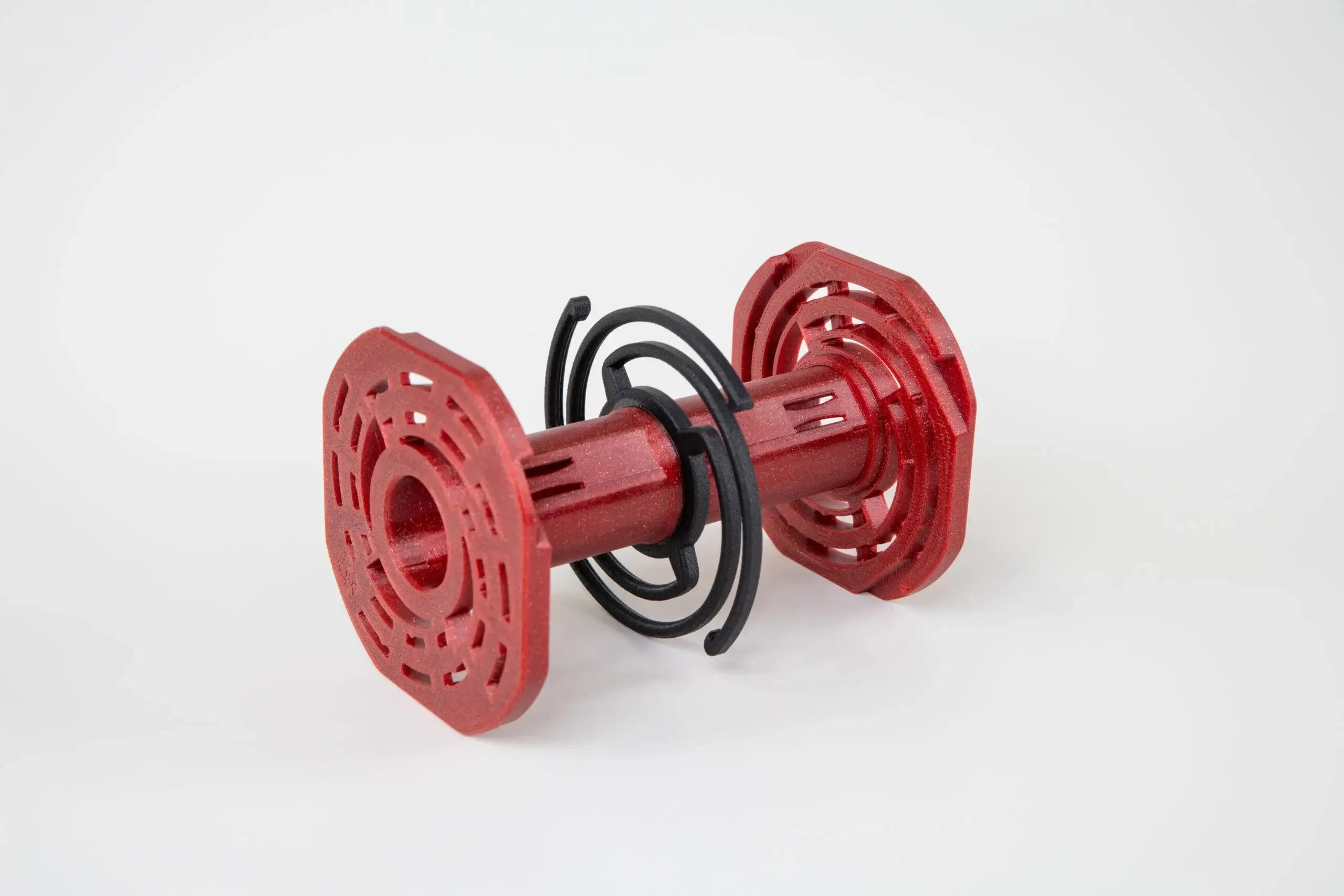 Red plastic toy with black spiral wire wrapped around its center.