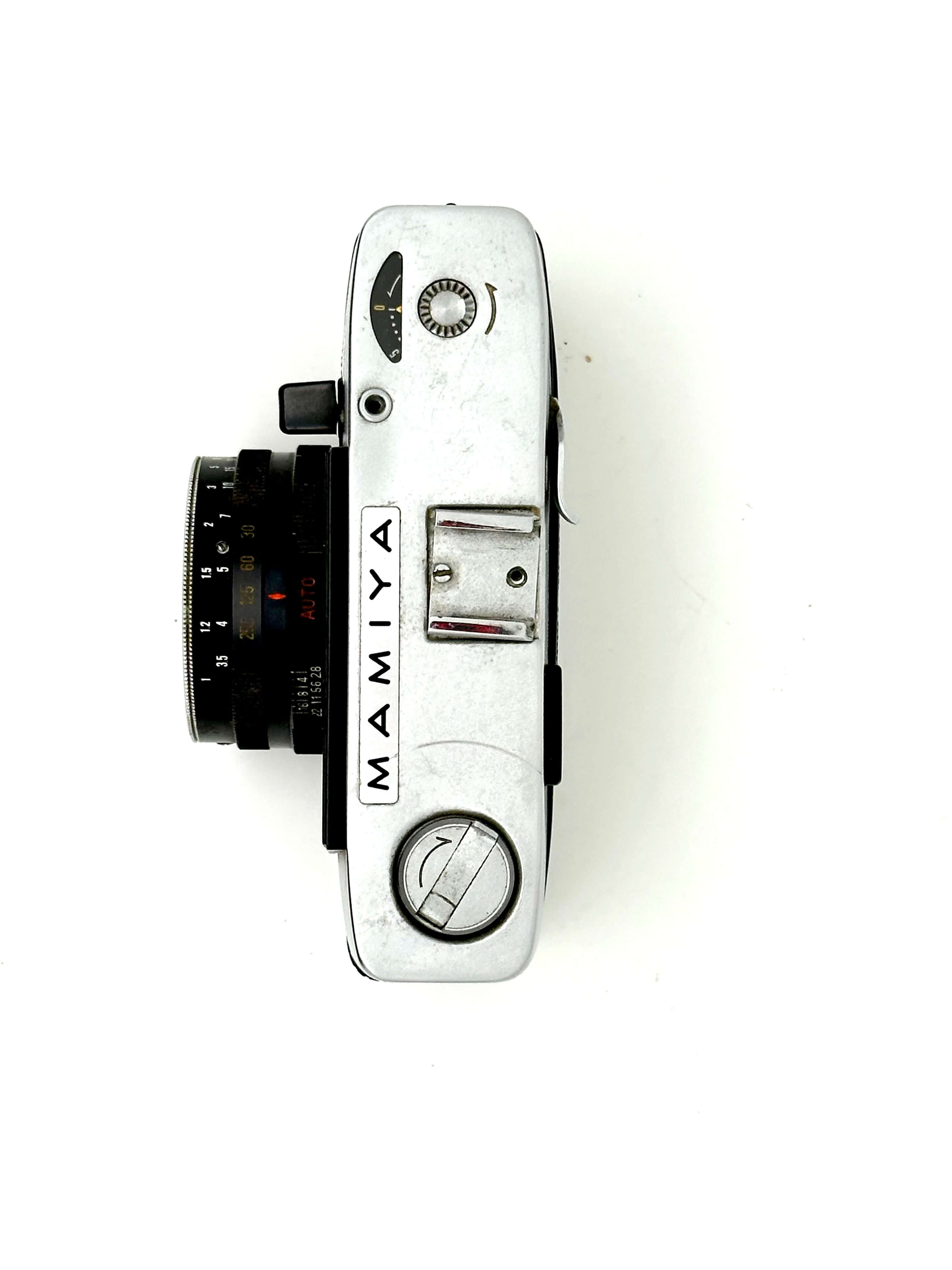 Silver-bodied mamiya film camera with a black lens and classic rangefinder design.