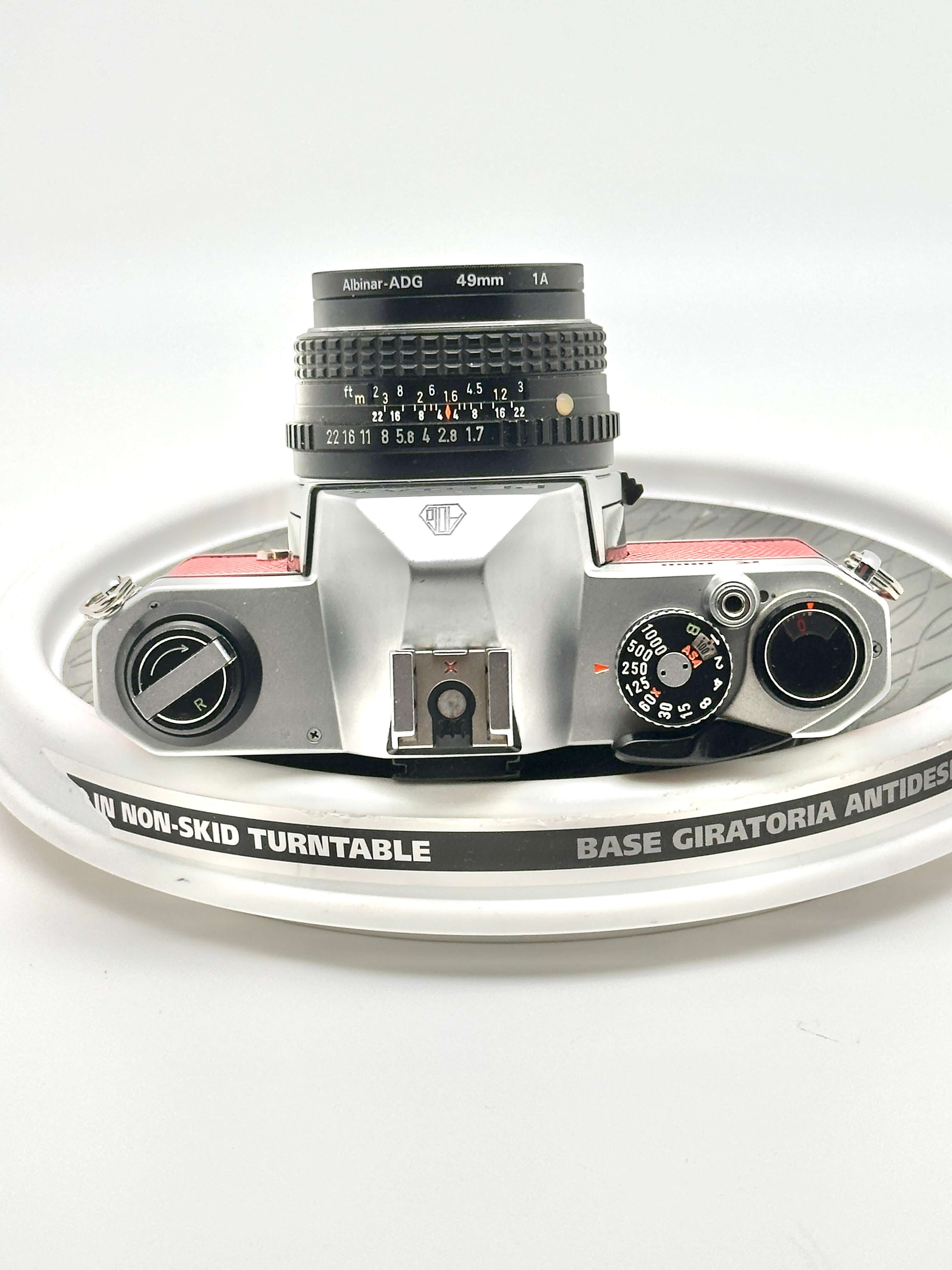 Silver and red albin-adg 49mm lens mounted on a vintage camera body.