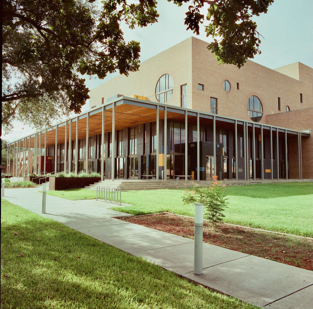 Modern brick building with large circular windows and a glass-enclosed entrance.