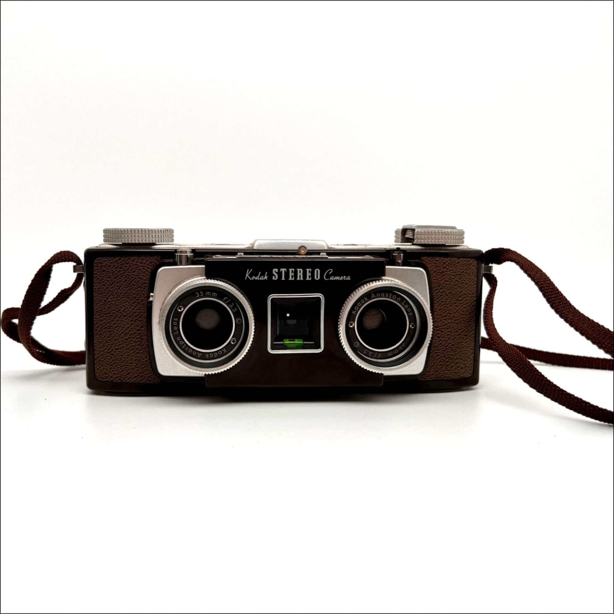 Brown leather-bodied kodak stereo camera with two silver-rimmed lenses and a matching brown strap.