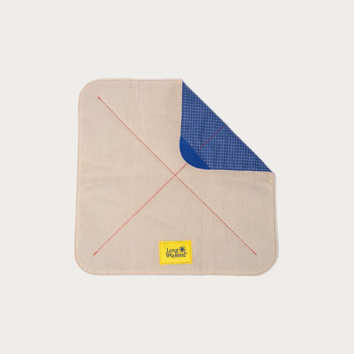 Long Weekend padded camera wrap with one corner folded back to show the blue grid ripstop lining