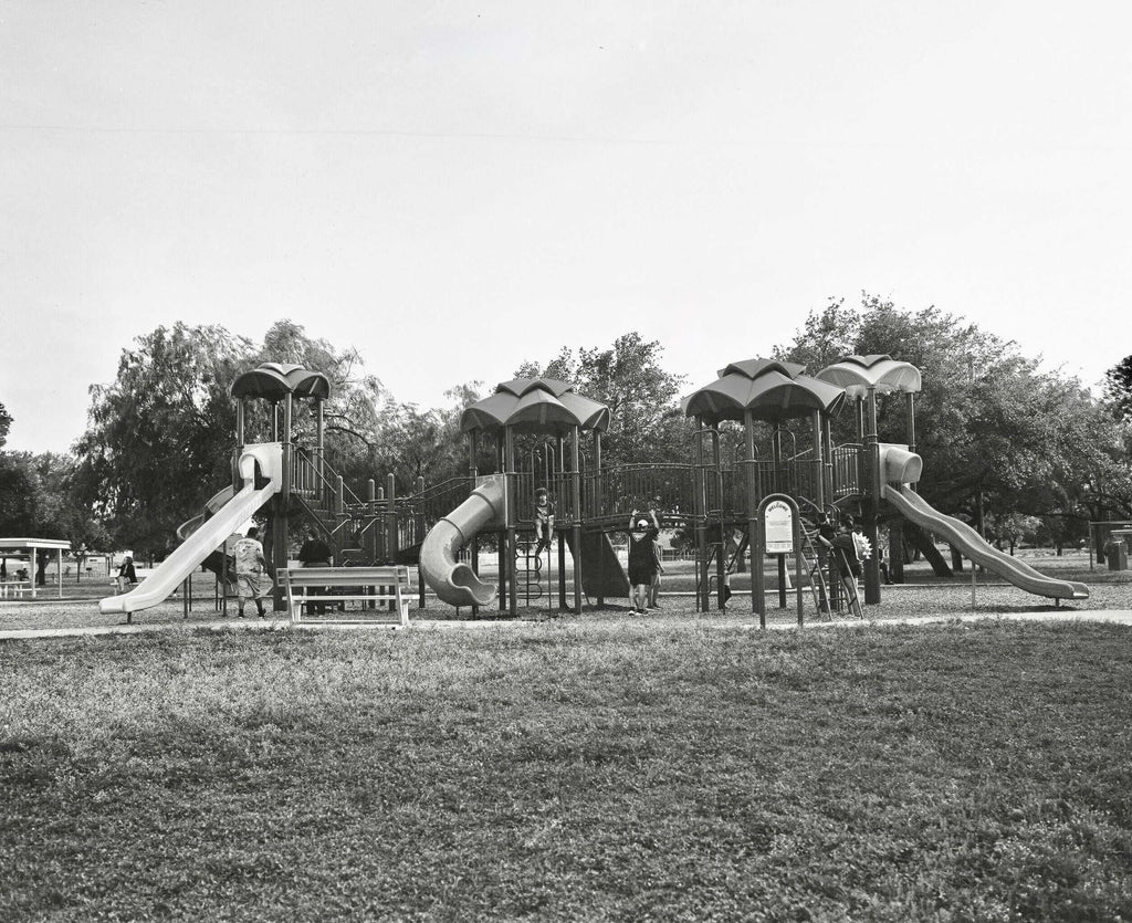 Black-and-white playground structure with multiple slides and climbing areas