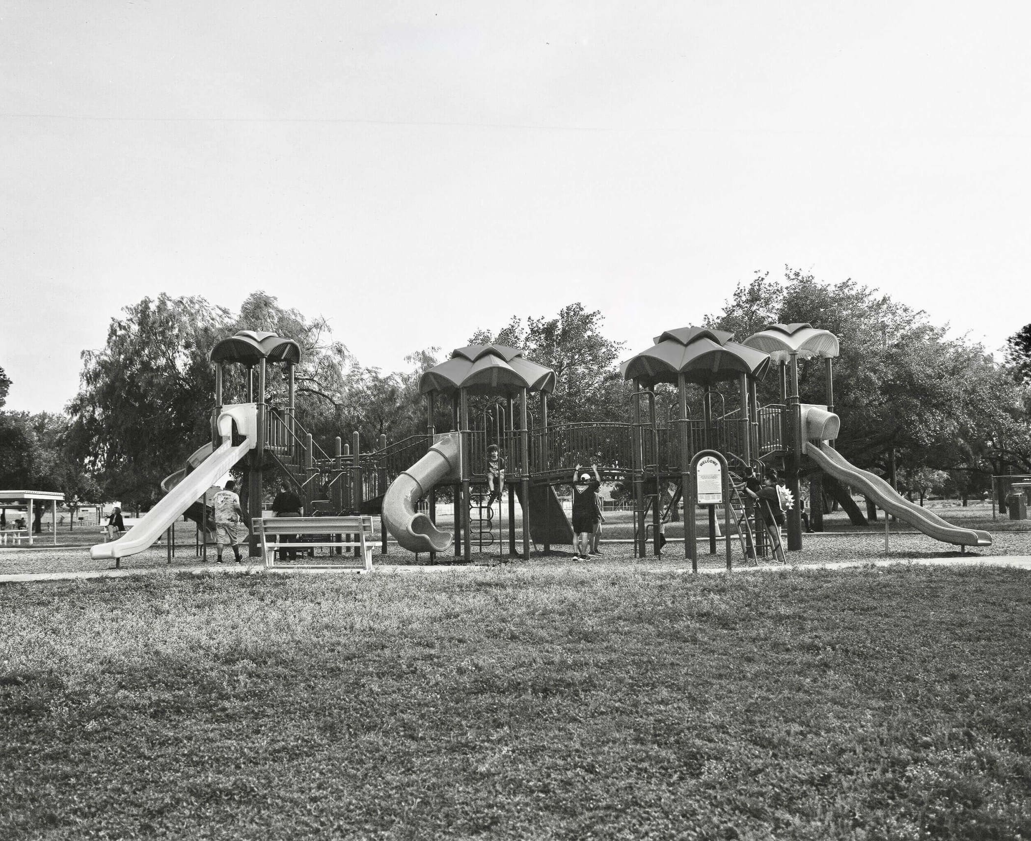 Black-and-white playground structure with multiple slides and climbing areas