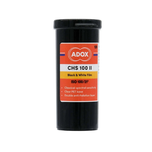 Black cylindrical container of adox chs 100 ii black and white film with an orange, white, and yellow label.