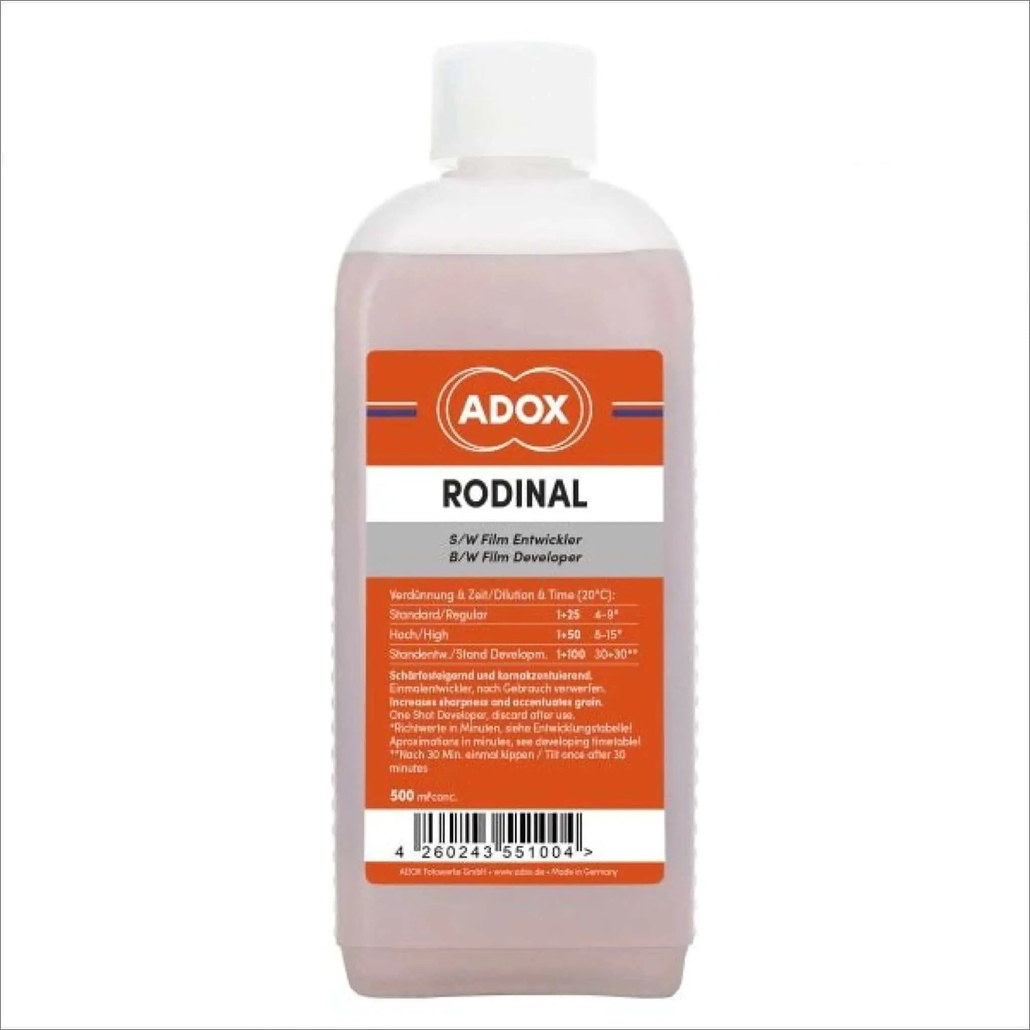 A translucent pink bottle of adox rodinal b/w film developer with a white cap and an orange label featuring black text.