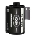 Black adox scala 50 black and white reversal film canister with silver text and a metallic gray sprocket.
