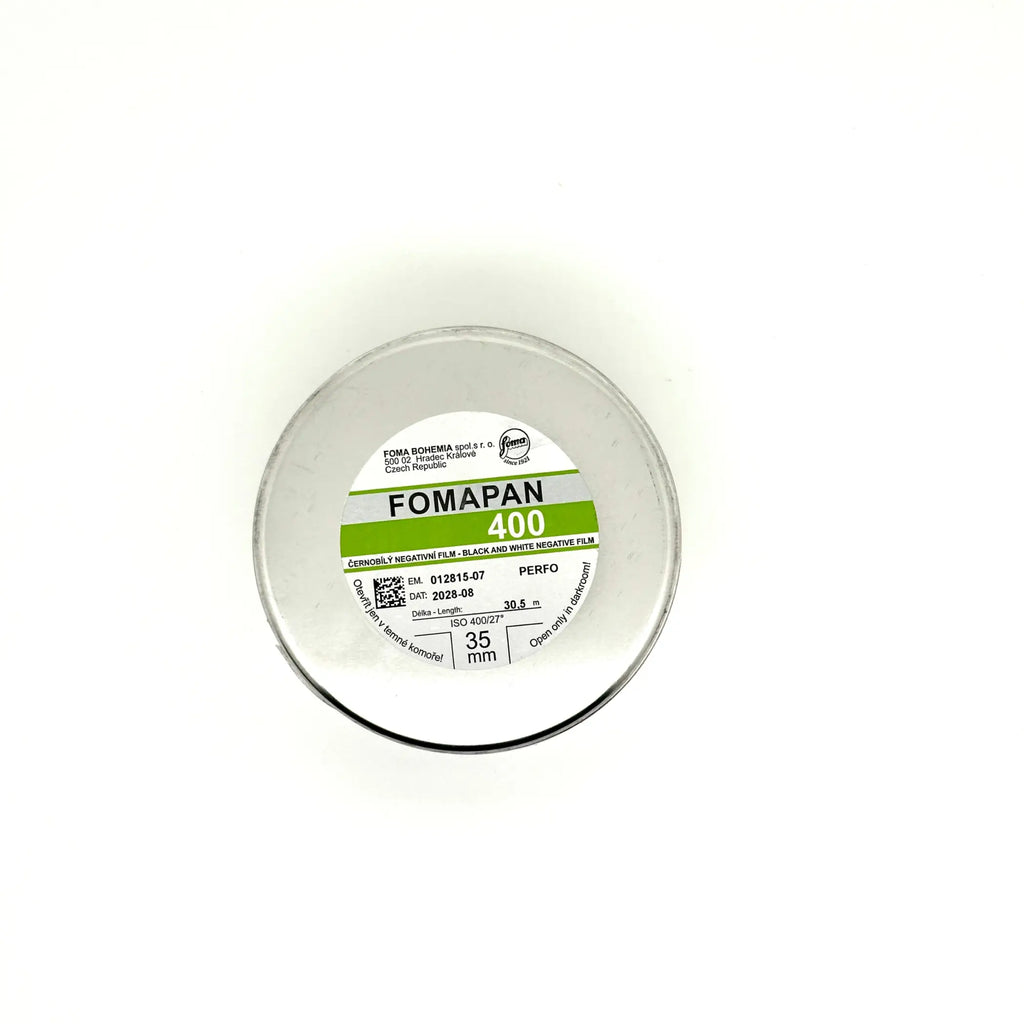 A circular container of fomapan 400 black and white negative film, featuring a clear plastic lid with printed specifications on its label.