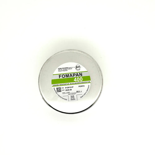 A circular container of fomapan 400 black and white negative film, featuring a clear plastic lid with printed specifications on its label.