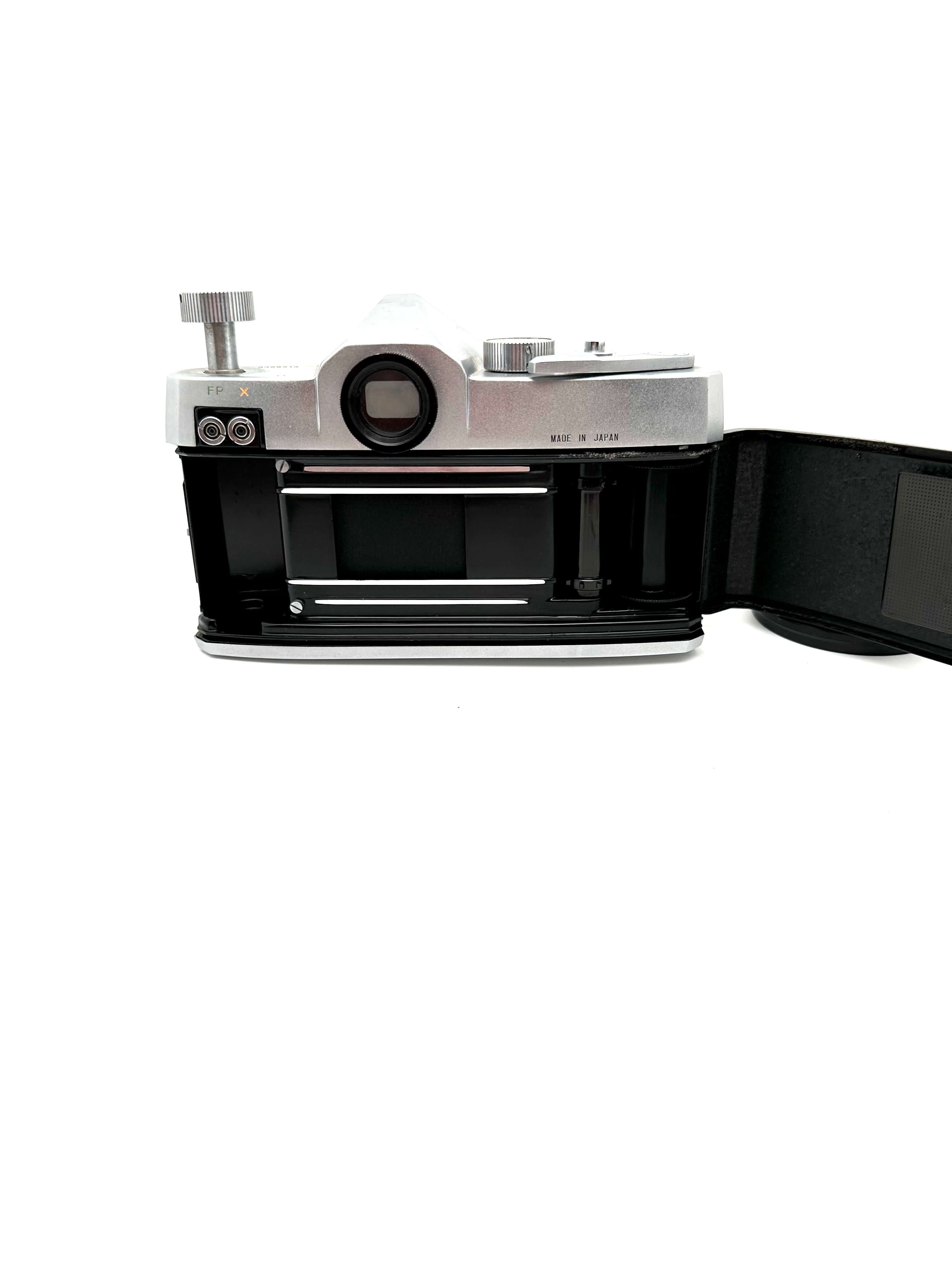 Silver and black canon ae-1 film camera with a hinged back open to reveal the film compartment.