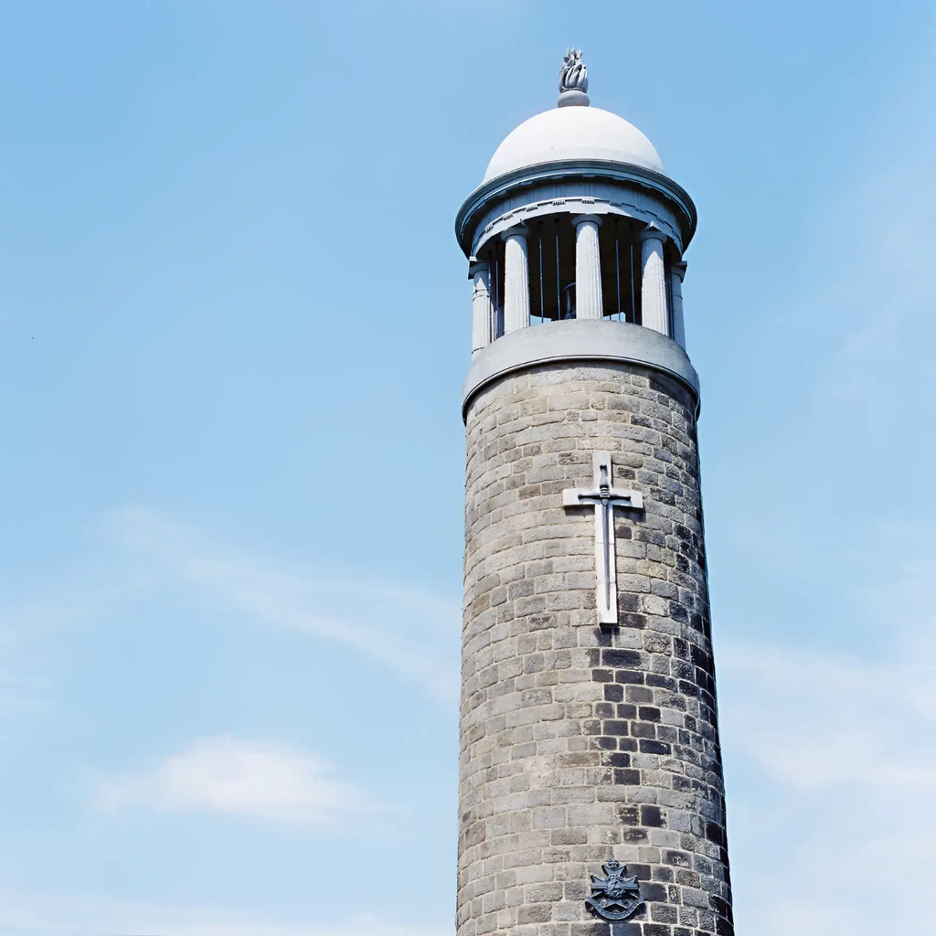 Gray stone bell tower with white domed top and silver cross captured on candido c41 color 400 iso 35mm color negative film