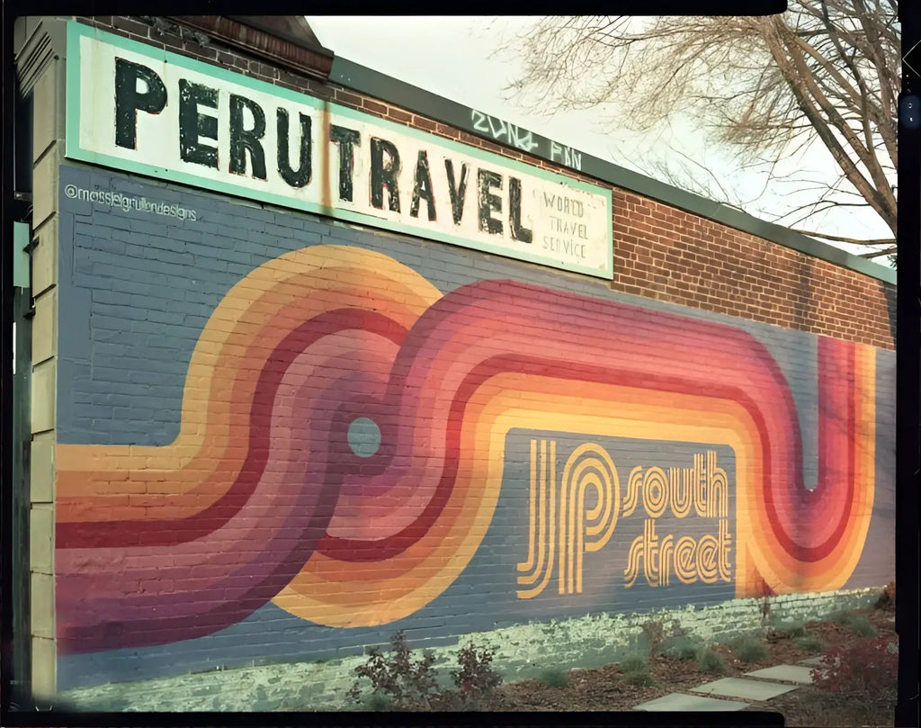 Vibrant retro-style mural with flowing rainbow stripes and south street logo on brick wall for catlabs x film color negative film