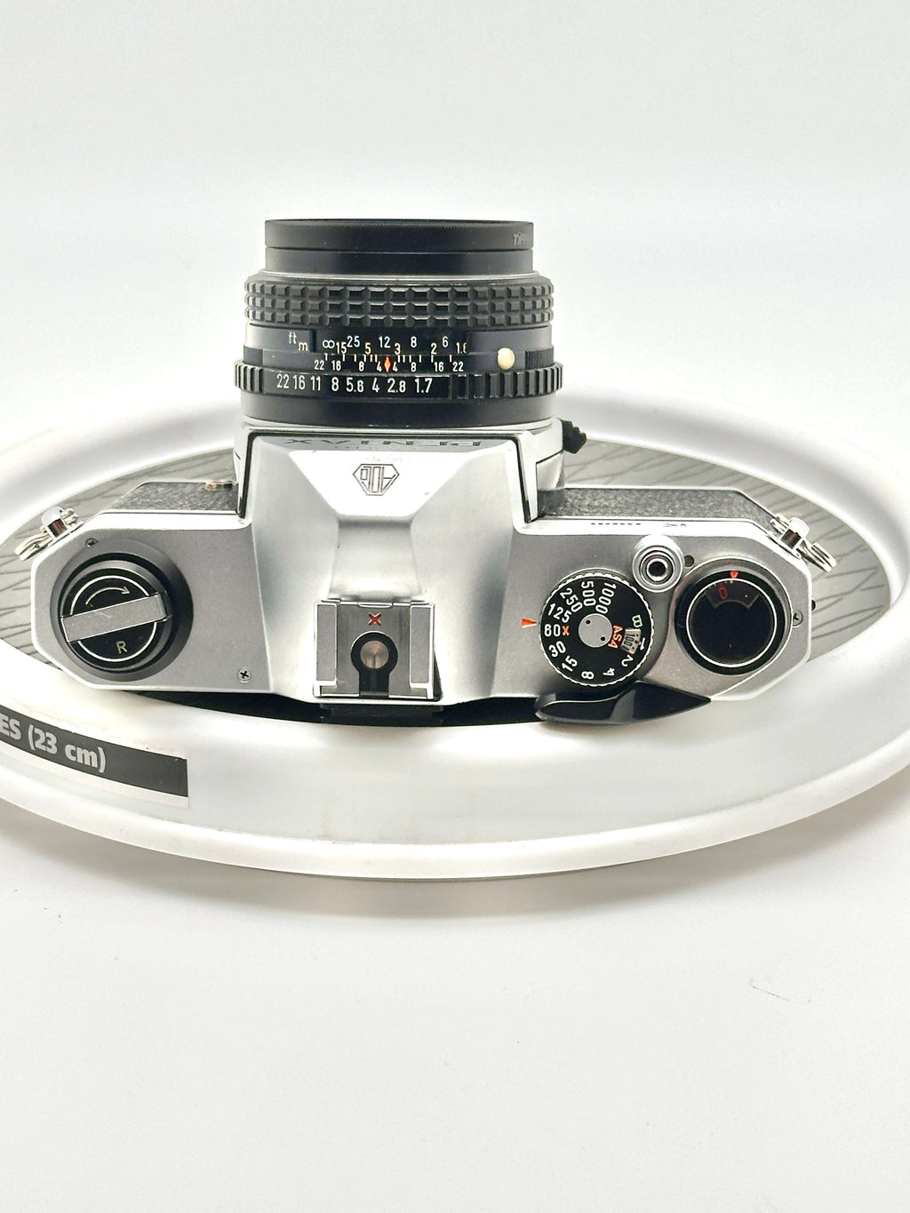 Silver-bodied canon ae-1 film camera with a black lens and textured grip.
