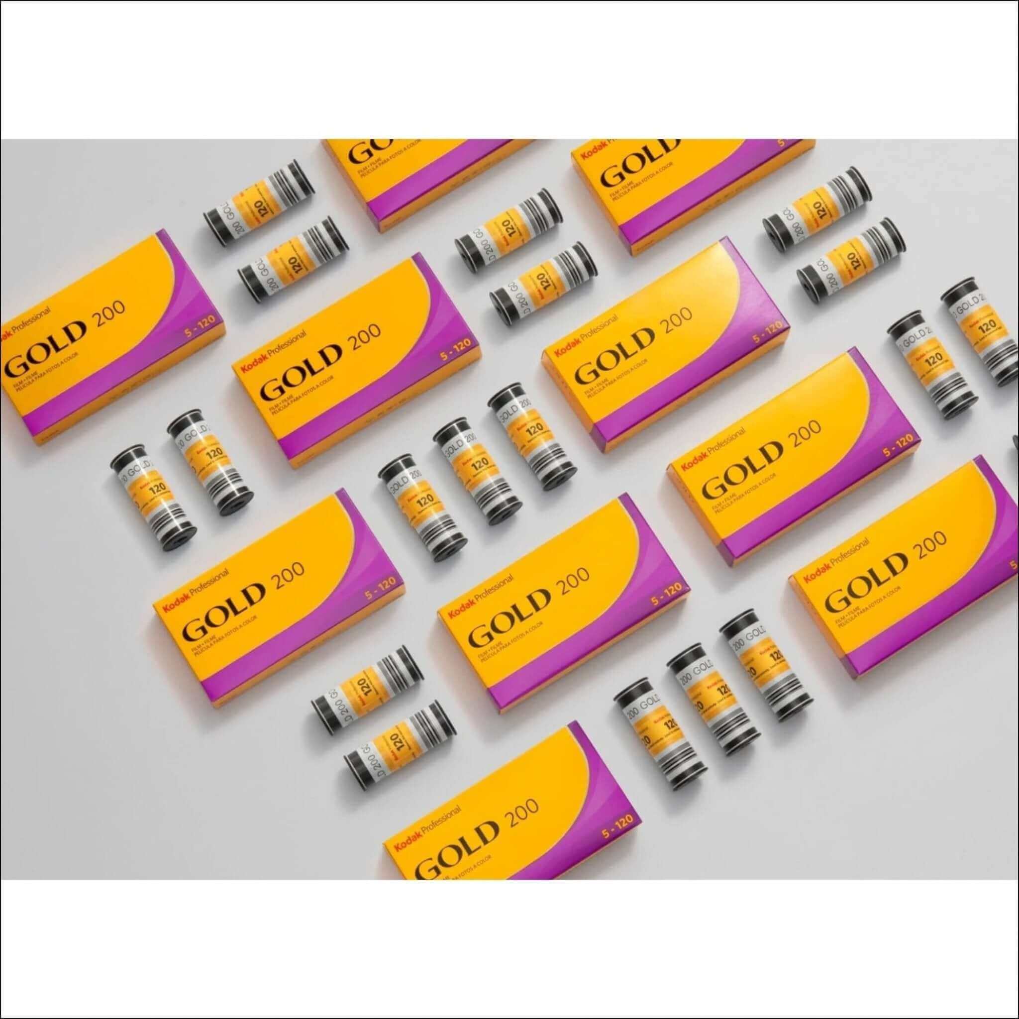 Vibrant yellow and purple kodak professional gold 200 film cartridges arranged neatly on a plain surface.