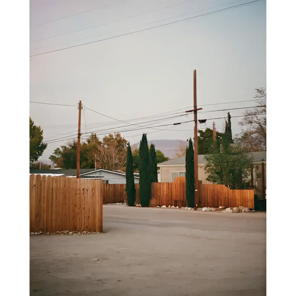 A weathered wooden fence with vertical slats, painted in a faded brown hue.