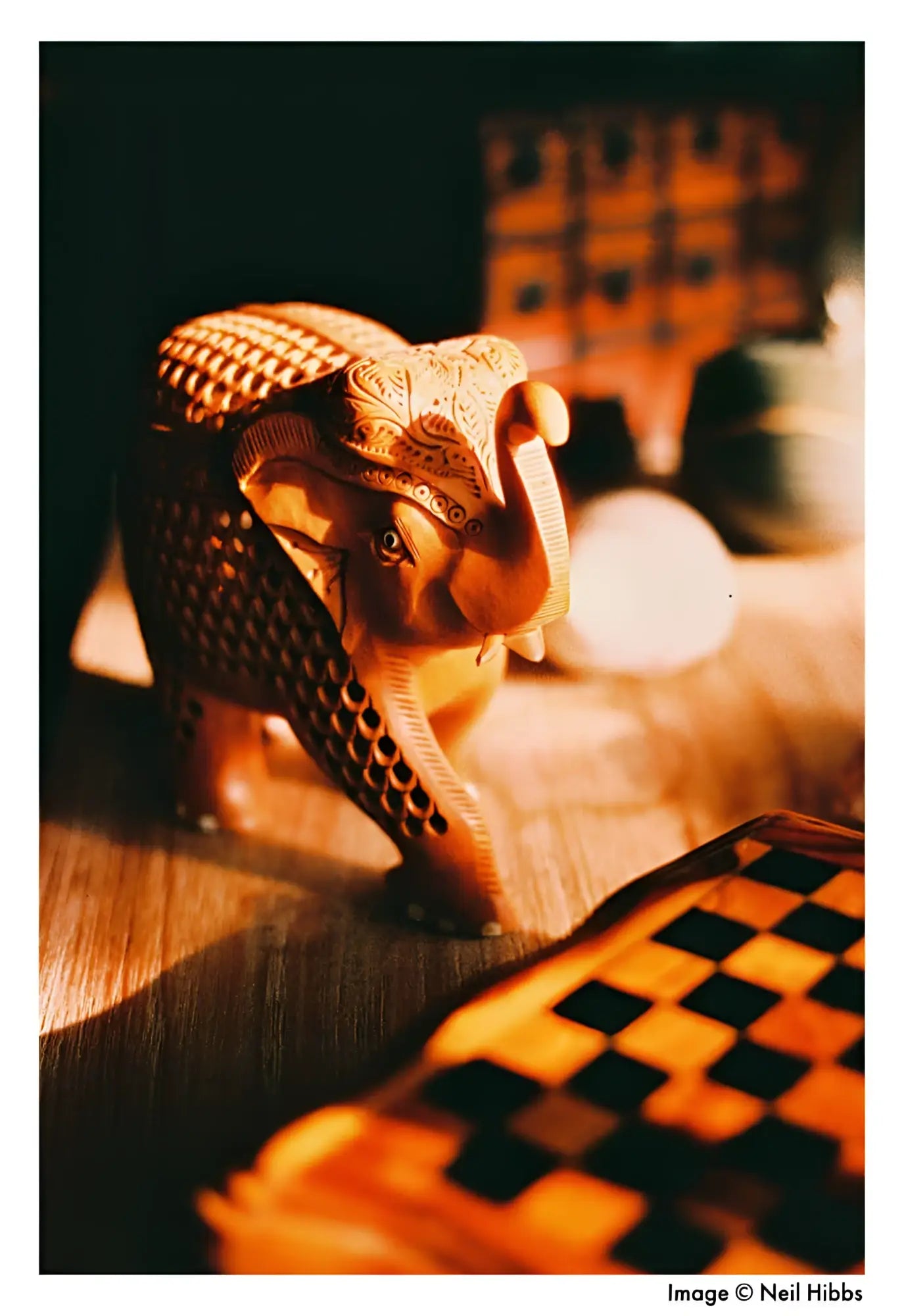 Carved wooden elephant figurine with intricate patterns and a warm, golden-brown finish.