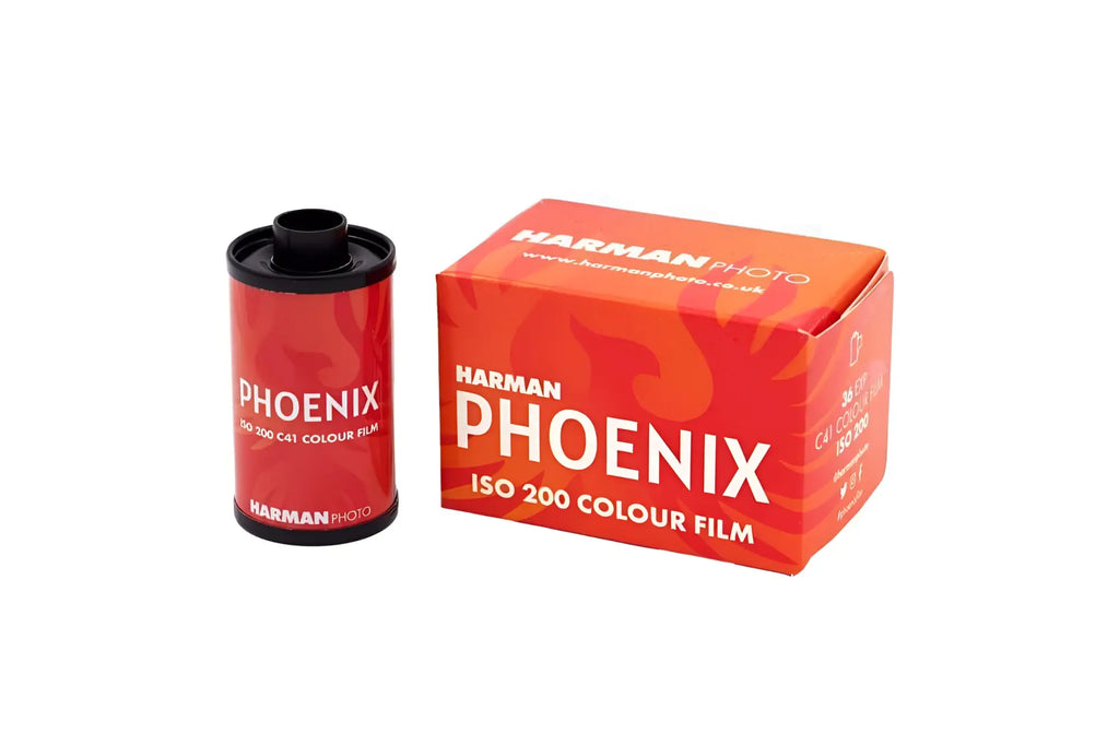Red harman phoenix iso 200 colour film canister with black cap next to its matching orange packaging.