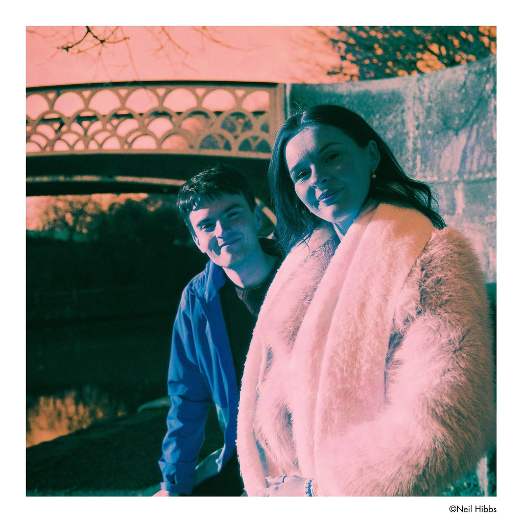 A plush, light pink faux fur coat with a soft, fluffy texture and a draped, open-front design.