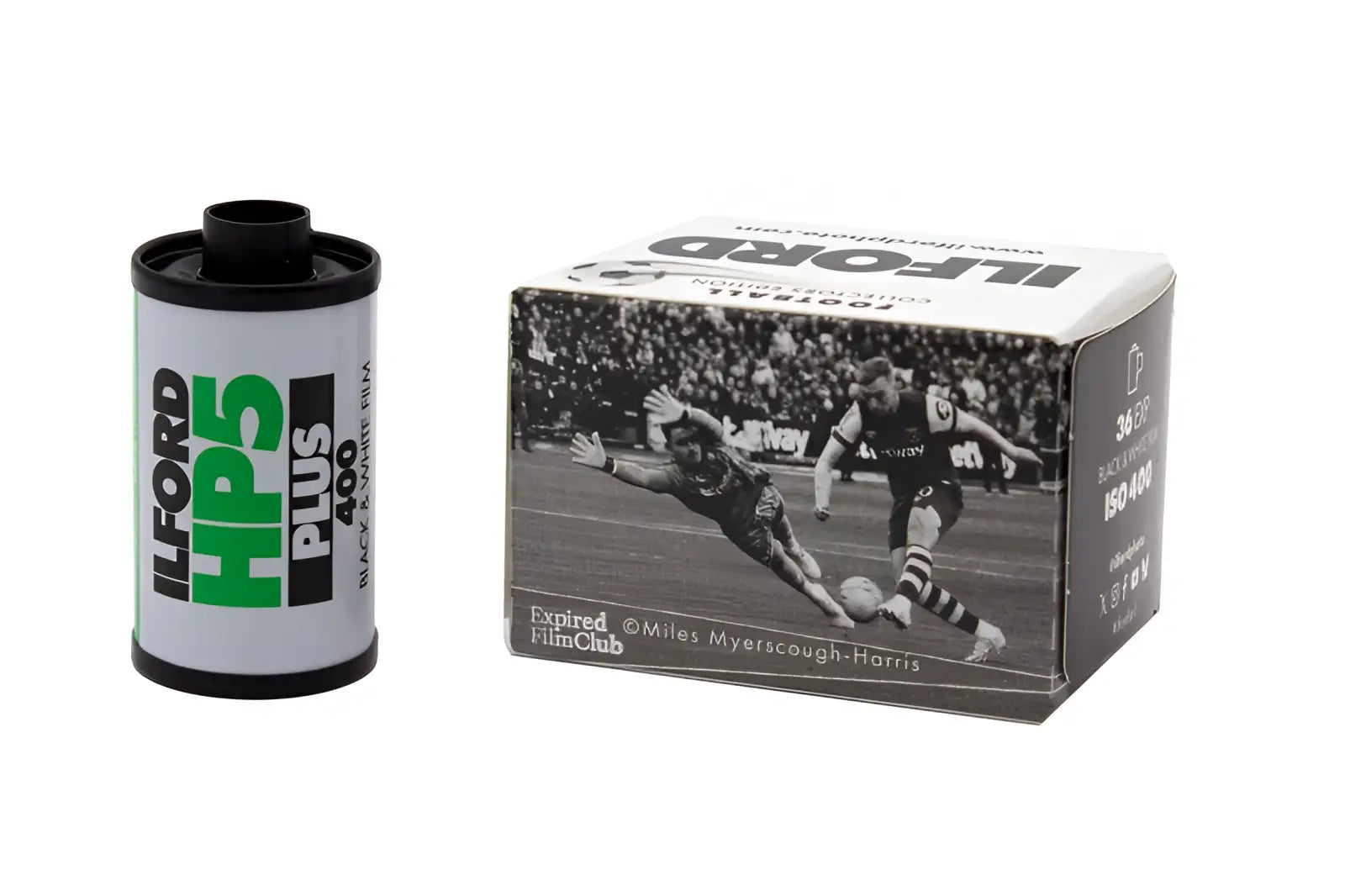 A cylindrical roll of ilford hp5 plus 400 black and white 35mm film with a green label next to its vintage football box