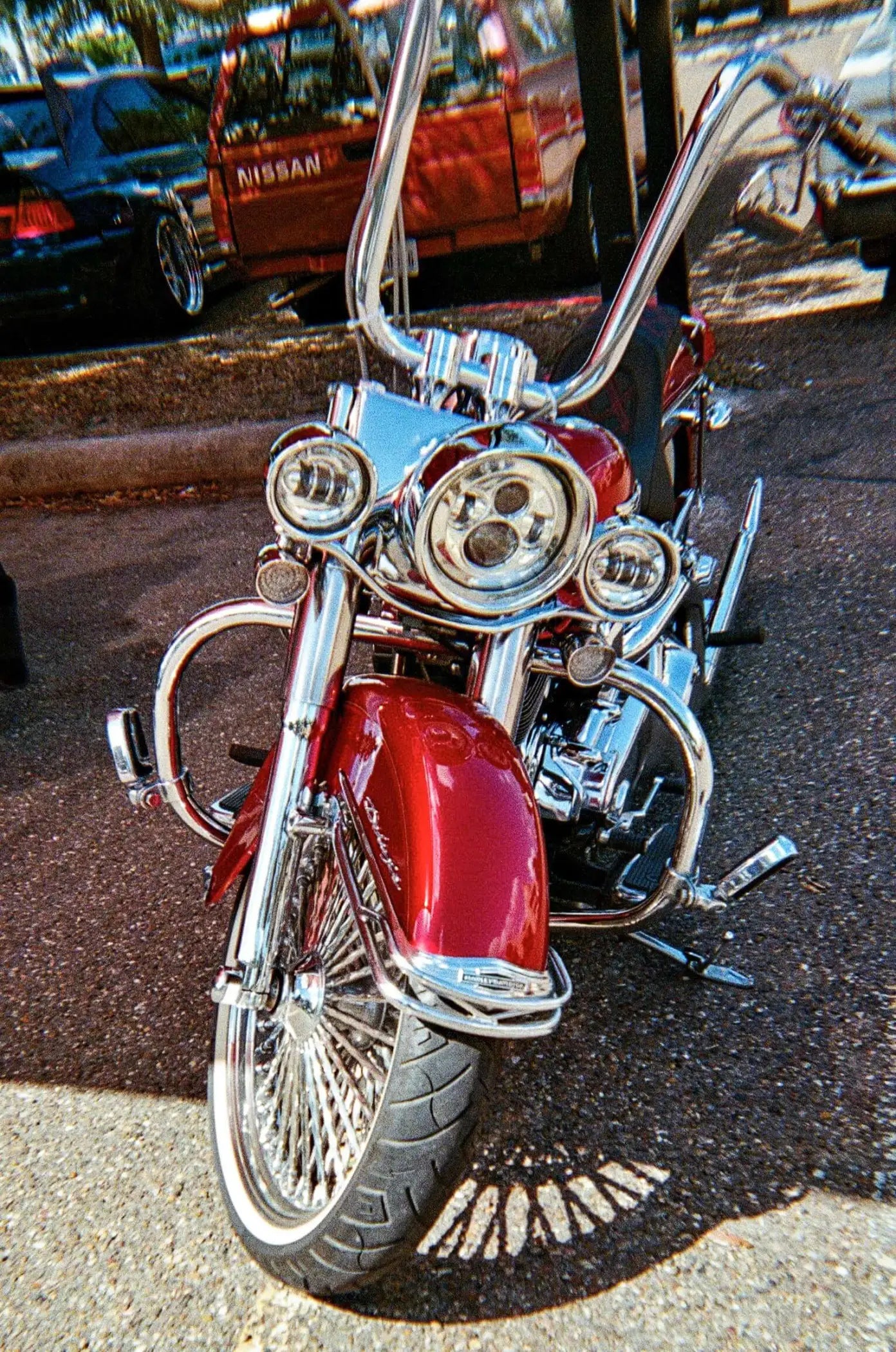 A gleaming red harley-davidson motorcycle with chrome handlebars and intricate detailing.