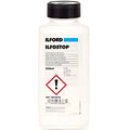 White plastic bottle with black cap, labeled ’ilford ilfostop’ as a perfumes stop bath for photographic processing.