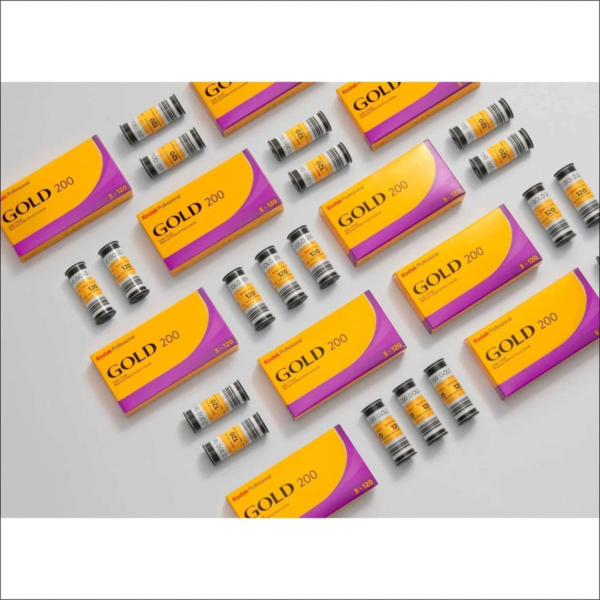 Vibrant yellow and purple kodak professional gold 200 film cartridges arranged neatly on a plain surface.