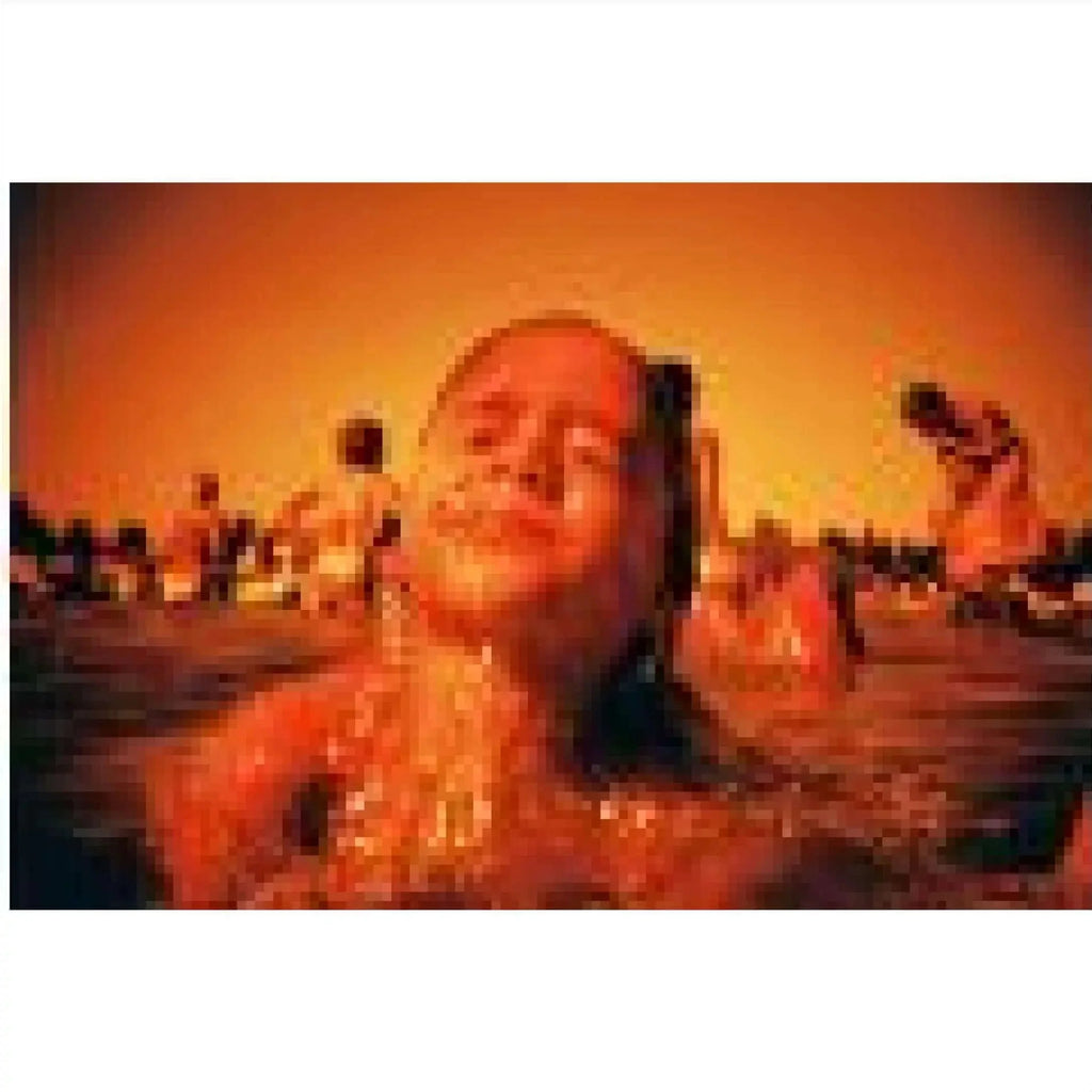 A smiling child with wet hair and a joyful expression, captured in warm orange-toned water.