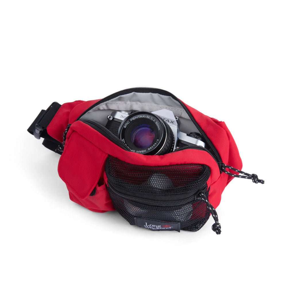 Red fabric monterey sling waist pack in chili red with black mesh pocket and zipper for long weekend use