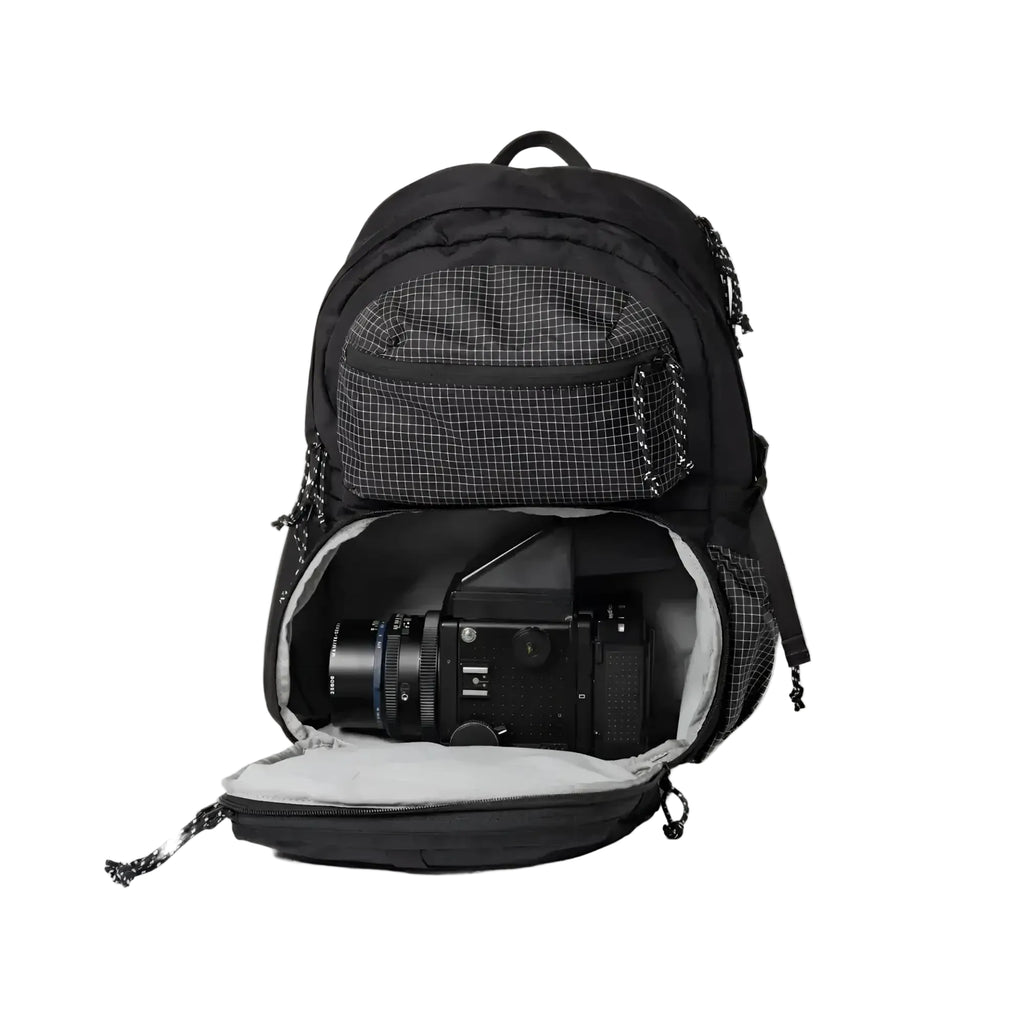 Black backpack with a grid-patterned front pocket and interior, designed to securely hold camera gear.