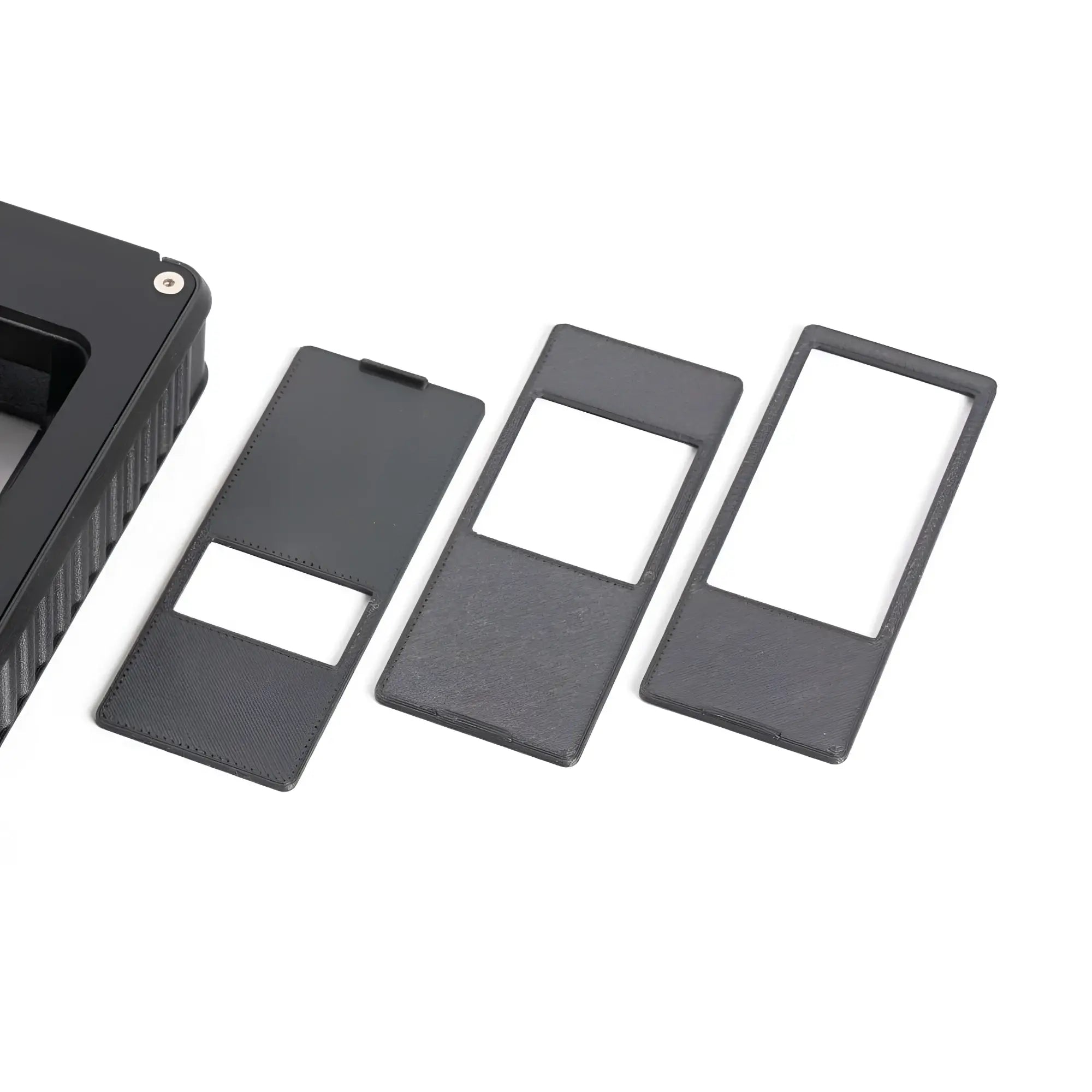 Set of three black rectangular slide covers with textured surfaces and white inner panels.