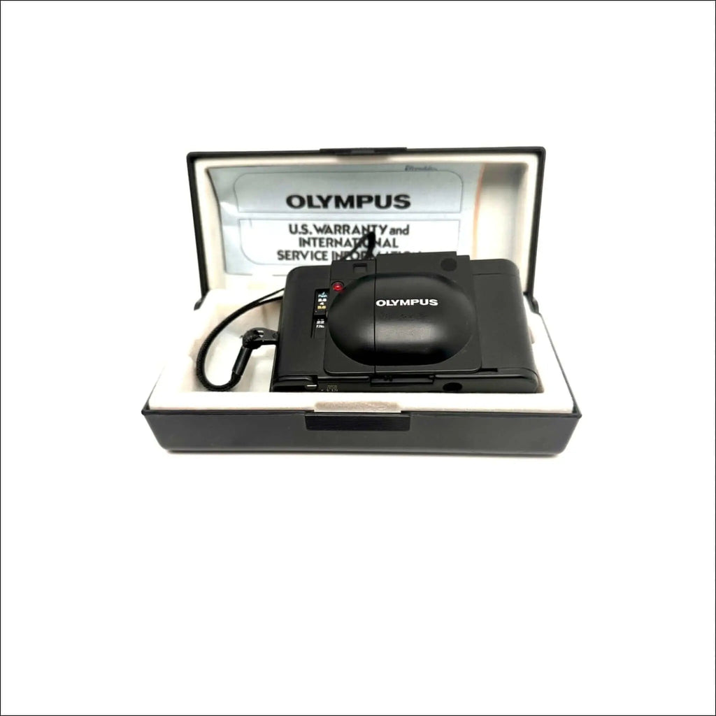 Black olympus camera with a sleek, compact design and glossy finish.